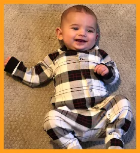 4 month old baby wearing a plaid onesie